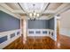 Charming dining room with hardwood floors, coffered ceiling, modern light fixture, and classic blue and white wainscoting at 2604 Heltonwood Ct, Buford, GA 30519