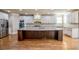 Gourmet kitchen with stainless steel appliances, granite counters, large center island, and custom white cabinetry at 2604 Heltonwood Ct, Buford, GA 30519