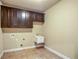 Functional laundry room with tile floor, cabinets, utility sink, and washer/dryer hookups at 2604 Heltonwood Ct, Buford, GA 30519