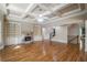 Open-concept living room with stone fireplace, hardwood floors, coffered ceilings, and access to the second floor and kitchen at 2604 Heltonwood Ct, Buford, GA 30519