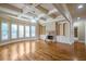 Spacious living room with built-in bookshelves, fireplace, coffered ceiling, hardwood floors and an abundance of windows at 2604 Heltonwood Ct, Buford, GA 30519