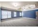 Large bedroom with blue walls, neutral carpeting, and large windows with natural light at 2604 Heltonwood Ct, Buford, GA 30519