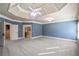 Spacious bedroom featuring tray ceiling, neutral carpet, and blue accent wall at 2604 Heltonwood Ct, Buford, GA 30519