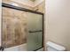 Shower with decorative tan tile and a glass door for an updated and clean look at 2604 Heltonwood Ct, Buford, GA 30519