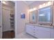 Bathroom featuring a granite-topped double sink vanity, storage, and a doorway to a walk-in shower at 295 Hanover Dr, Villa Rica, GA 30180