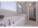 Bright bathroom features a soaking tub, shower with glass door, and a linen closet at 295 Hanover Dr, Villa Rica, GA 30180