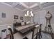 Elegant dining room features coffered ceilings, a stylish chandelier, and a spacious table set for a delightful meal at 295 Hanover Dr, Villa Rica, GA 30180