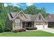 Charming stone and siding home with well-manicured lawn and a three-car garage at 295 Hanover Dr, Villa Rica, GA 30180