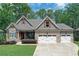 Charming stone and siding home with well-manicured lawn and a three-car garage at 295 Hanover Dr, Villa Rica, GA 30180