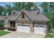 Charming stone and siding home with well-manicured lawn and a three-car garage at 295 Hanover Dr, Villa Rica, GA 30180