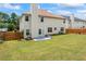 Expansive backyard featuring a lush green lawn and a patio, complemented by a privacy fence and mature trees at 507 Vaughan Dr, Hampton, GA 30228
