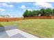 Large, well-manicured backyard featuring a privacy fence, a concrete patio, and ample green space for outdoor activities at 507 Vaughan Dr, Hampton, GA 30228