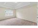 Bright, spacious bedroom featuring neutral carpet, tray ceiling, and a window providing natural light and an airy feel at 507 Vaughan Dr, Hampton, GA 30228