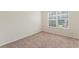 Bright bedroom with neutral carpet, base trim and paint, with a window providing natural light and views at 507 Vaughan Dr, Hampton, GA 30228