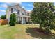 Charming two-story brick home with a well-manicured lawn and a large tree in the front yard at 507 Vaughan Dr, Hampton, GA 30228