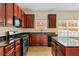 Spacious kitchen with dark wood cabinets, granite countertops, and stainless steel appliances at 507 Vaughan Dr, Hampton, GA 30228