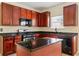 Well-equipped kitchen featuring an island, dark wood cabinetry and black appliances at 507 Vaughan Dr, Hampton, GA 30228