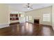 Bright living room featuring a fireplace, hardwood flooring, and an open layout, connected to the kitchen area at 507 Vaughan Dr, Hampton, GA 30228