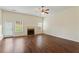 Open-concept living room featuring a fireplace, hardwood flooring, a ceiling fan, and access to the backyard at 507 Vaughan Dr, Hampton, GA 30228
