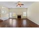 Open-concept living room featuring a fireplace, hardwood flooring, a ceiling fan, and access to the backyard at 507 Vaughan Dr, Hampton, GA 30228