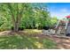 Expansive backyard featuring a fire pit area, mature trees, and lush green grass at 1274 Cotton Gin Dr, Powder Springs, GA 30127