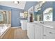 This blue hued bathroom features a tub, shower, double vanity sinks, and tile floor at 1274 Cotton Gin Dr, Powder Springs, GA 30127