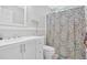 Bright bathroom featuring a single sink vanity with storage and patterned shower curtain at 1274 Cotton Gin Dr, Powder Springs, GA 30127