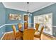 Elegant dining room with blue accent wall, hardwood floors, bright natural light, and white trim at 1274 Cotton Gin Dr, Powder Springs, GA 30127