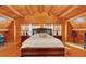 Inviting bedroom showcasing wood floors, wood-paneled ceiling, and a comfy queen-sized bed with traditional lamps at 179 Hogan Rd, Brooks, GA 30205