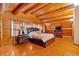 Cozy bedroom featuring wood floors, wood-paneled ceiling, and a comfortable queen size bed with side tables at 179 Hogan Rd, Brooks, GA 30205