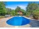 Sparkling swimming pool with ample space for lounging, surrounded by lush landscaping and trees at 179 Hogan Rd, Brooks, GA 30205