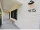Close up of the exterior of a house showing the address number, covered porch, and white brick wall at 1815 Coventry Rd, Decatur, GA 30030