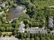An aerial view of a community with a lake, mature trees, and well-maintained townhomes at 2728 Wander Ln, Alpharetta, GA 30022