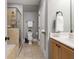 This main bathroom features stone floors and shower, a wooden cabinet, and a sink and toliet at 2728 Wander Ln, Alpharetta, GA 30022