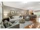 Bright living room with hardwood floors, white sofa, and open layout to dining area at 2728 Wander Ln, Alpharetta, GA 30022