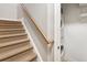 Carpeted stairwell featuring a stacked washer/dryer and wooden handrail at 2728 Wander Ln, Alpharetta, GA 30022