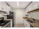 Galley kitchen with granite countertops, white cabinets, and stainless steel appliances at 3655 Habersham Ne Rd # 203, Atlanta, GA 30305