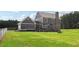 Large grassy backyard and patio on a home with a stone chimney at 615 Henderson Mill Rd, Covington, GA 30014