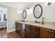 Elegant bathroom featuring dual sinks with granite countertop, dark cabinetry, and hardwood floors at 615 Henderson Mill Rd, Covington, GA 30014