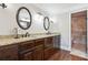 Elegant bathroom featuring dual sinks with granite countertop, dark cabinetry, and tiled walk-in shower at 615 Henderson Mill Rd, Covington, GA 30014