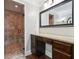 Bathroom vanity featuring granite countertop, dark wood cabinets, and tiled walk-in shower with glass door at 615 Henderson Mill Rd, Covington, GA 30014