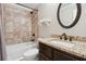 Updated bathroom with granite countertops, tiled shower, white toilet and dark wood vanity at 615 Henderson Mill Rd, Covington, GA 30014