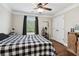 Bedroom featuring a black and white checkered bed, ceiling fan, and view of the backyard at 615 Henderson Mill Rd, Covington, GA 30014