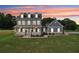 Inviting two-story home with a covered front porch and well-manicured lawn against a colorful sky at 615 Henderson Mill Rd, Covington, GA 30014
