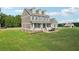 Two-story home featuring a welcoming front porch and large lawn with fence and backyard basketball court at 615 Henderson Mill Rd, Covington, GA 30014