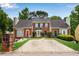 Traditional brick townhouse with mature trees, driveway, and manicured lawn at 1368 Poplar Pointe Se, Smyrna, GA 30082
