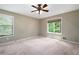 Bright bedroom features neutral tones, carpet, ceiling fan, and windows providing natural light at 148 Bramble Oak Dr, Woodstock, GA 30188
