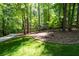 The home is surrounded by lush landscaping, offering privacy with driveway and mature trees at 148 Bramble Oak Dr, Woodstock, GA 30188
