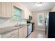 Modern kitchen featuring stainless steel appliances, tile floors, and bright cabinets at 148 Bramble Oak Dr, Woodstock, GA 30188