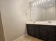 Bathroom featuring a double sink vanity with dark wood cabinets and a large mirror at 2141 Spikerush Way, Buford, GA 30519
